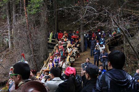 九寨沟珍珠滩瀑布，二十四位身着藏羌民族服饰的姑娘小伙们从瀑顶栈道拾级而下